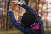 Rückansicht einer Frau beim Stretching im Park — Stockfoto