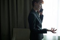 Mulher de negócios falando no telefone celular no quarto de hotel — Fotografia de Stock