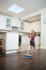Ragazzo pulizia pavimento con scopa in cucina a casa — Foto stock