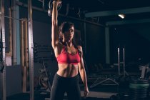Mujer en forma haciendo ejercicio con kettlebell en el gimnasio - foto de stock