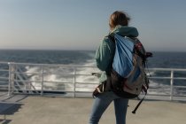 Visão traseira da mulher com mochila de pé no navio de cruzeiro — Fotografia de Stock