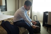 Businessman tying shoes laces in hotel room — Stock Photo
