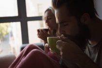 Coppia che prende un caffè in soggiorno a casa — Foto stock
