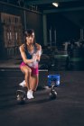 Fit woman dusting her hands with chalk powder in the gym — Stock Photo