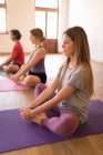 Gruppe von Menschen, die Yoga-Übungen im Fitnessclub durchführen — Stockfoto