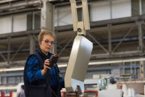 Máquina operadora de técnico femenino en la industria metalúrgica - foto de stock