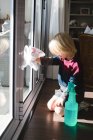 Хлопчик прибирає вікно ганчіркою вдома — стокове фото