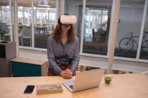 Esecutivo femminile utilizzando cuffie realtà virtuale in ufficio — Foto stock