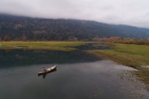 Мужской турист, путешествующий на каноэ на озере — стоковое фото