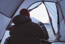 Rückansicht eines Mannes beim Kaffee im Zelt — Stockfoto