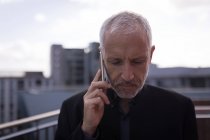 Бизнесмен разговаривает по мобильному телефону в помещениях отеля — стоковое фото