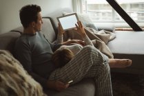 Пара, використовуючи цифровий планшетний у вітальні на дому — стокове фото