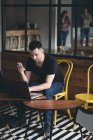 Бизнесмен использует ноутбук в кафетерии в офисе — стоковое фото