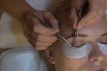 Kosmetikerin behandelt Kundin im Salon mit Wimpernverlängerung — Stockfoto