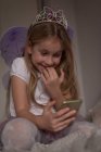 Mädchen benutzt Handy im Schlafzimmer zu Hause — Stockfoto