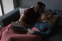 Homem beijando mulher em sua testa na sala de estar em casa — Fotografia de Stock
