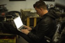 Seitenansicht des Mechanikers mit Laptop in der Garage — Stockfoto