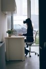 Exécutif travaillant sur un ordinateur portable tout en utilisant un casque de réalité virtuelle au bureau — Photo de stock