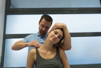 Fisioterapeuta dando massagem à mulher na clínica — Fotografia de Stock