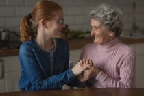 Grandmother and granddaughter interacting with each other in kitchen at home — Stock Photo