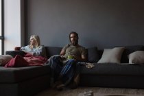 Casal ignorando uns aos outros na sala de estar em casa — Fotografia de Stock