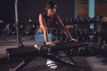 Вмістити жінку вправляється на тренажерній лавці в спортзалі — стокове фото
