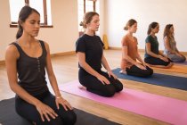 Gruppe von Frauen meditiert gemeinsam im Fitnessclub — Stockfoto