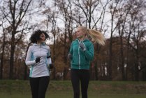 Zwei junge Freundinnen beim Joggen im Park — Stockfoto