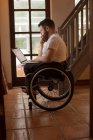 Инвалид молодой человек с ноутбуком дома — стоковое фото