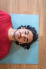 Молодой человек медитирует в фитнес-клубе — стоковое фото