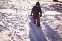Menina andando com trenó na neve durante o inverno — Fotografia de Stock
