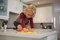 Мальчик убирает кухонный стол тряпкой дома — стоковое фото