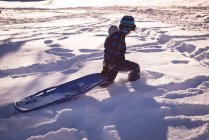 Дівчина гуляє з санчатами на снігу взимку — стокове фото