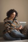 Mulher usando tablet digital na sala de estar em casa — Fotografia de Stock