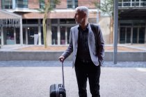 Empresário entrando no hotel com bagagem — Fotografia de Stock