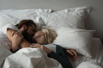 Пару цілуватися один з одним в спальні в домашніх умовах — стокове фото