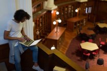 Молодий чоловік використовує ноутбук у бібліотеці — стокове фото