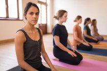 Группа женщин медитирует вместе в фитнес-клубе — стоковое фото