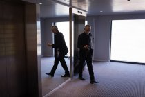 Empresario caminando por el ascensor en un hotel - foto de stock