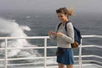 Frau benutzt Handy auf Kreuzfahrtschiff — Stockfoto