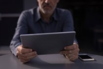 Mittelteil des Geschäftsmannes hält digitales Tablet im Hotelzimmer — Stockfoto