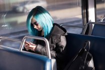 Стильна жінка використовує мобільний телефон під час подорожі в поїзді — стокове фото
