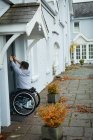 Людина з обмеженими можливостями відкриває двері свого будинку — стокове фото