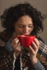 Primo piano della donna che ha caffè soggiorno a casa — Foto stock