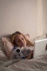 Mädchen benutzt digitales Tablet zu Hause im Schlafzimmer — Stockfoto