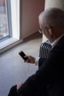 Uomo d'affari che utilizza uno smartphone in camera d'albergo — Foto stock