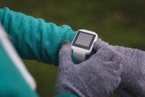 Close-up of woman using smartwatch in the park — Stock Photo