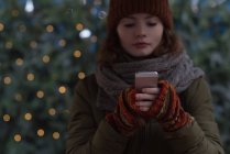 Belle femme en vêtements d'hiver en utilisant le téléphone mobile — Photo de stock