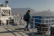Продумана жінка з рюкзаком, що стоїть на круїзному кораблі — стокове фото