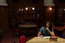 Молодий чоловік навчається в бібліотеці — стокове фото